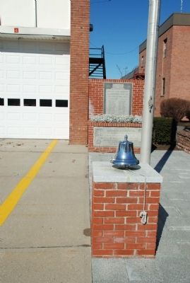 Memorial marker is behind the traditional firehouse bell image, Touch for more information