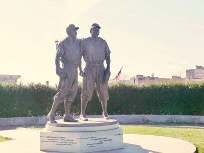 Monument depicting Brooklyn Dodgers Pee Wee Reese and Jackie Robinson with  Reese's arm around Robinson. It …